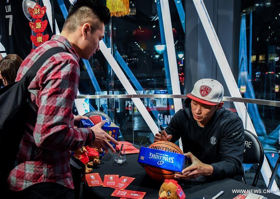 Brooklyn Nets guard Jeremy Lin (R) signs autograph for a fan at a Chinese New Year celebration at the NBA store on Manhattan 5th Avenue, New York City, the United States, on Jan. 24, 2017. Brooklyn Nets guard Jeremy Lin said on Monday he expected to be back to action in 3-5 weeks from his left hamstring injury. (Xinhua/Li Rui) 