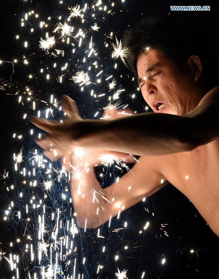 A villager performs 'firework eating' in Huadong Village, Putian City of southeast China's Fujian Province, Feb. 12, 2017.