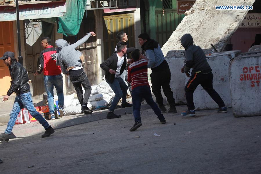Palestinian protesters hurl stones at Israeli security forces during a protest demanding the opening of the Al-Shuhada Street which has been closed by Israeli authority for many years in the West Bank city of Hebron, on Feb. 24, 2017.
