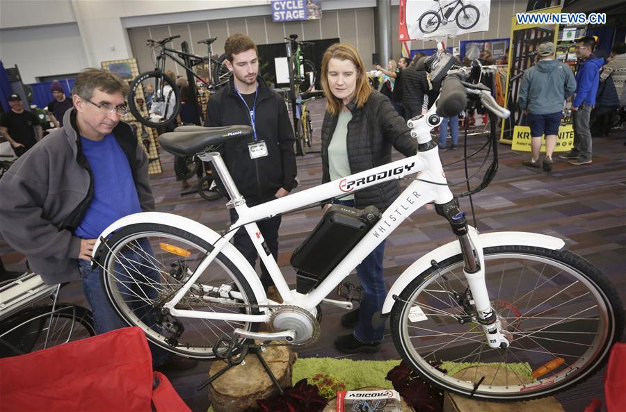 People look at an electric mountain bicycle displayed at the Vancouver Bike Show in Vancouver, Canada, March 4, 2017. 