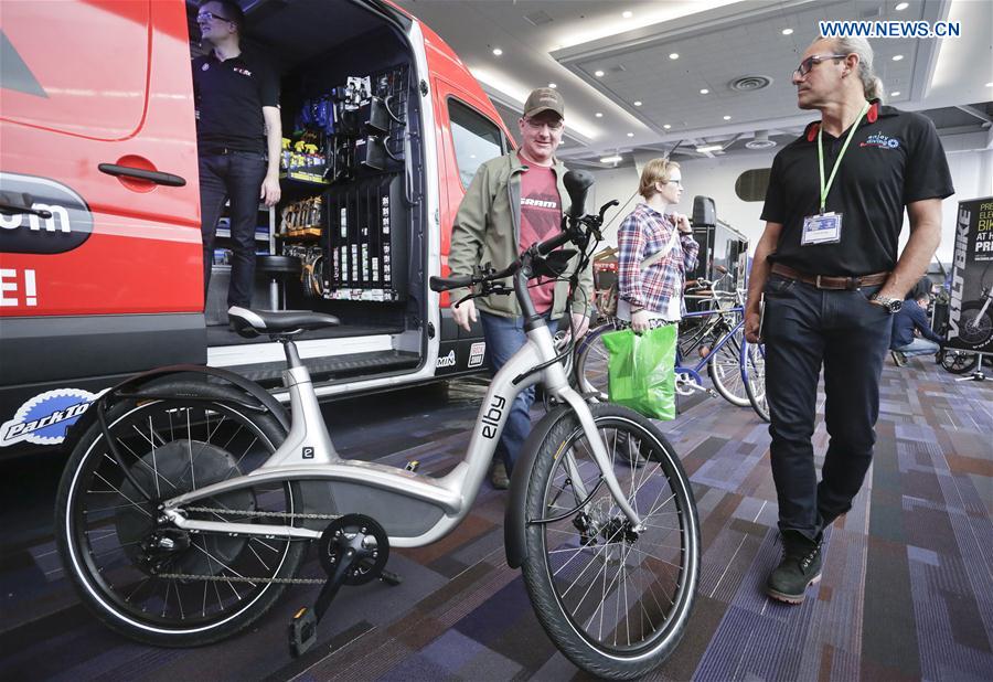 People look at an electric mountain bicycle displayed at the Vancouver Bike Show in Vancouver, Canada, March 4, 2017. 