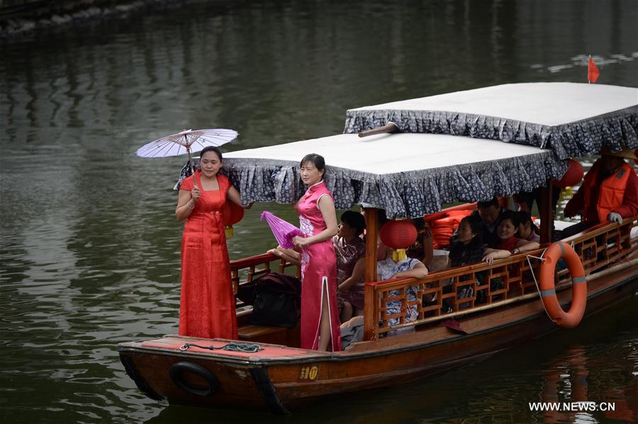 Women present Qipao at a scenic area of Feixi County, east China's Anhui Province, March 6, 2017.