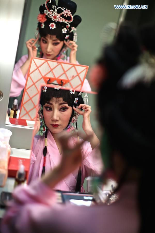 Zhang Jiachun, who plays the role of Gretchen, puts on makeup backstage before the performance of experimental Peking opera 'Faust' in Rome, Italy, March 12, 2017. 