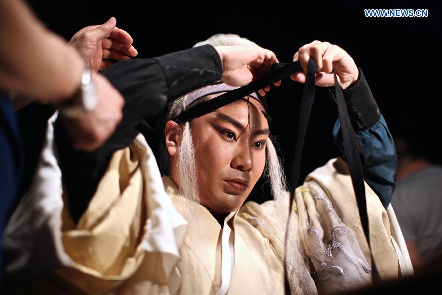 Liu Dake, who plays the role of Faust, puts on makeup backstage before the performance of experimental Peking opera 'Faust' in Rome, Italy, March 12, 2017.