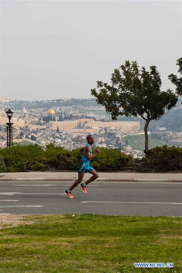 A runner takes part in the 7th International Jerusalem Winner Marathon in Jerusalem, on March 17, 2017. (Xinhua/Guo Yu)