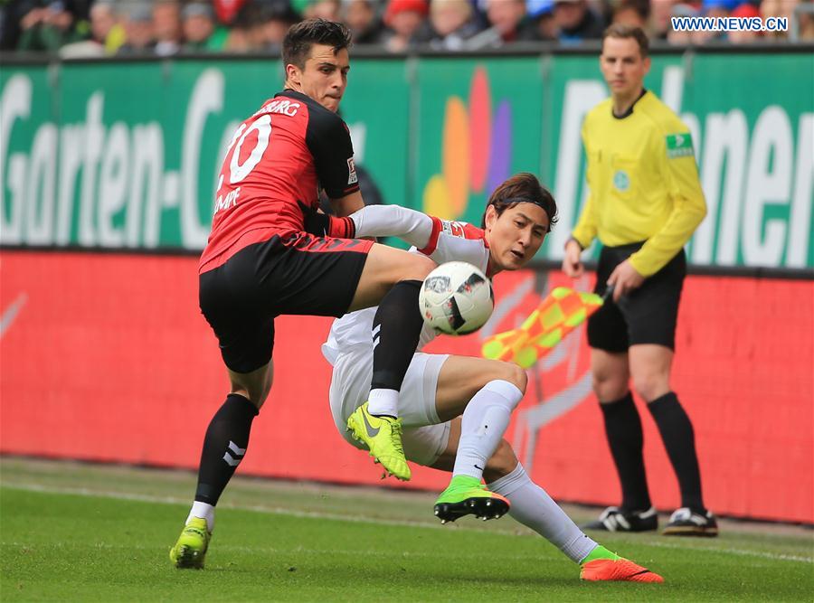 Augsburg's Ji Dong-Won (R) vies with Freiburg's Marc-Oliver Kempf during a German Bundesliga match between FC Augsburg and SC Freiburg in Augsburg, Germany, on March 18, 2017. 