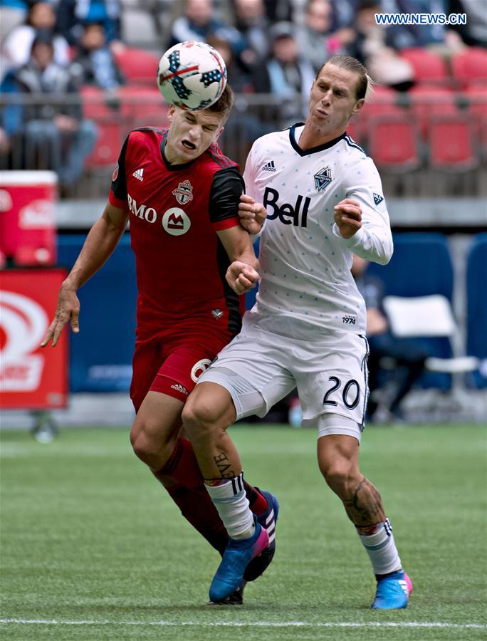 Toronto FC's Nick Hagglund (L) vies with Vancouver Whitecaps' Brek Shea during a Major League Soccer (MLS) game between Toronto FC and Vancouver Whitecaps in Vancouver, Canada, on March 18, 2017. 
