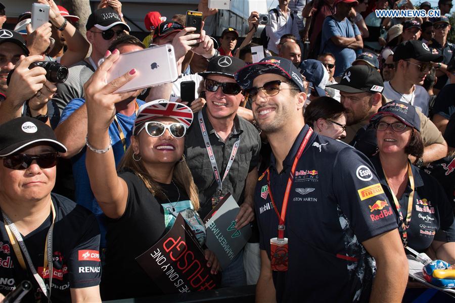Red Bull Racing Formula One driver Daniel Ricciardo(R) of Australia poses for selfies with his fans as he arrives for the third practice session ahead of the Australian Formula One Grand Prix at Albert Park circuit in Melbourne, Australia on March 25, 2017.