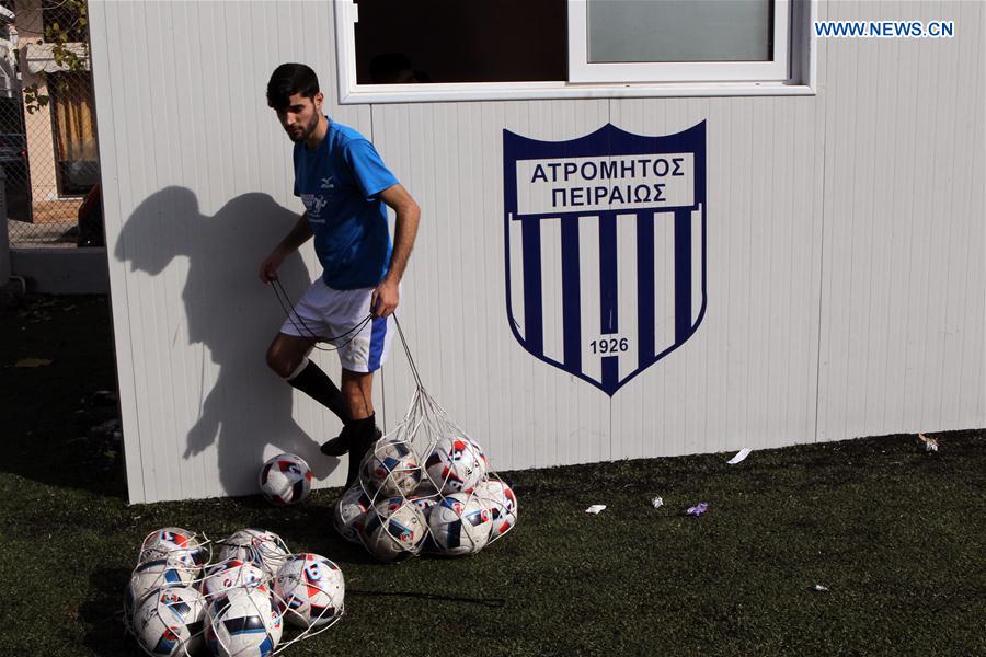 A player of Refugee's Athletic Hope Football Club collects balls during a friendly match in Piraeus, Greece, on March 13, 2017.
