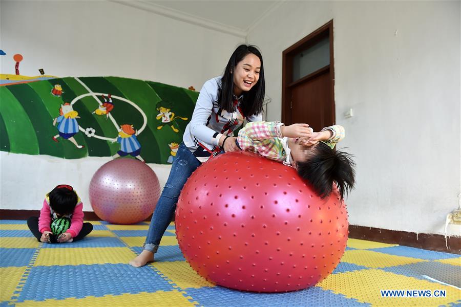 Teacher Li Xiaojiao works during a sensory integration training for autistic children at a service center of the Lingxing community in Taiyuan, capital of north China's Shanxi Province, March 29, 2017. Established in 2010, the service center has accommodated over 60 children with autism. A total of 29 teachers take part in the rehabilitation program to help these children. April 2 marks the World Autism Awareness Day. (Xinhua/Zhan Yan) 