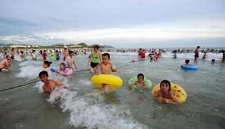 Residents take "dragon bath" over Dragon Boat Festival holidays, S China