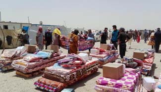 Displaced people gather at camp to receive relief goods in Iraq