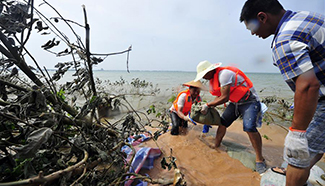 Villagers reinforce dike of Shijiu Lake in E China