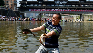 People catch fish in river to celebrate good harvest in C. China