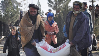 Afghan people carry winter relief assistance