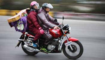 S China's migrant workers ride motorbike for family reunion in Spring Festival