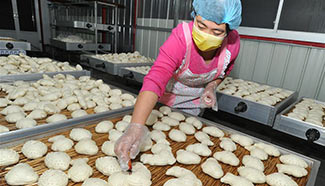 Cooks make traditional steamed buns for Spring Festival, N China