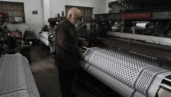 Palestinian employees work at Keffiyeh textile factory in West Bank