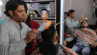 Palestinian barber uses fire in hair-straightening technique in salon