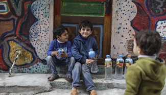 Refugees get drinking water from public taps in Gaza City