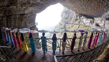 Qipao show presented on plank road built along vertical cliff in SW China
