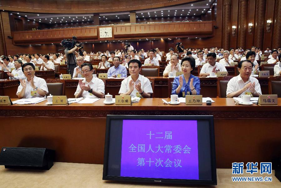 8月31日，十二屆全國人大常委會第十次會議在北京人民大會堂閉幕。這是出席人員在表決後鼓掌。 新華社記者劉衛兵攝 
