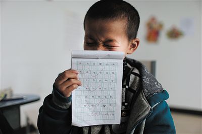 坤坤向記者展示自己的語文作業。入校半個月，坤坤從什麼拼音都不會説和寫，如今已經能寫幾個拼音字母，還能基本背誦一兩首詩。