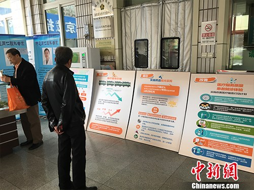 北京普仁醫院外，有人在細讀醫改宣傳板。湯琪 攝