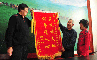 呼格吉勒圖父母向新華社內蒙古分社和記者湯計贈送錦旗