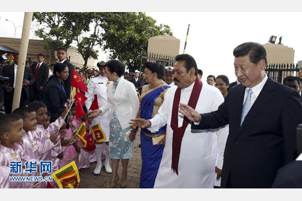 9月16日，斯裏蘭卡總統拉賈帕克薩在科倫坡為國家主席習近平舉行盛大歡迎儀式。斯裏蘭卡兒童身著節日服裝，站在紅地毯兩側，揮舞中斯兩國國旗。習近平和夫人彭麗媛走到孩子們面前向他們問好。新華社記者鞠鵬攝