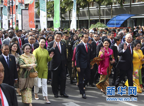 這是習近平和夫人彭麗媛同印度尼西亞總統佐科夫婦等走在隊伍前列，一邊走一邊向道路兩旁的人群揮手致意。新華社記者 蘭紅光 攝