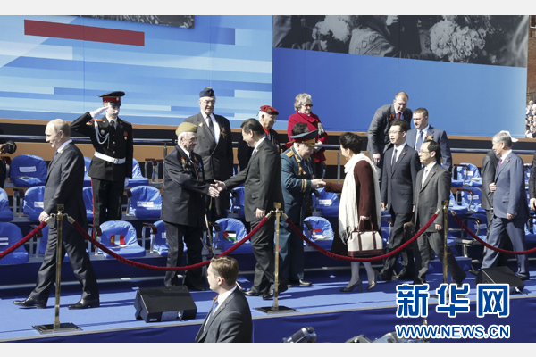 習近平和夫人彭麗媛在檢閱臺上同老戰士親切握手。新華社記者 鞠鵬 攝
