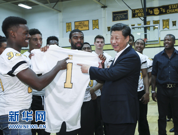 9月23日，國家主席習近平參觀美國塔科馬市林肯中學。這是習近平接受學生們贈送的橄欖球衣。 新華社記者蘭紅光攝