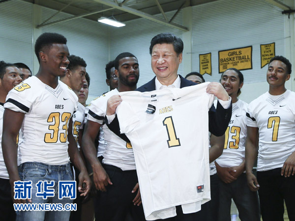 9月23日，國家主席習近平參觀美國塔科馬市林肯中學。這是習近平接受學生們贈送的橄欖球衣。 新華社記者蘭紅光攝