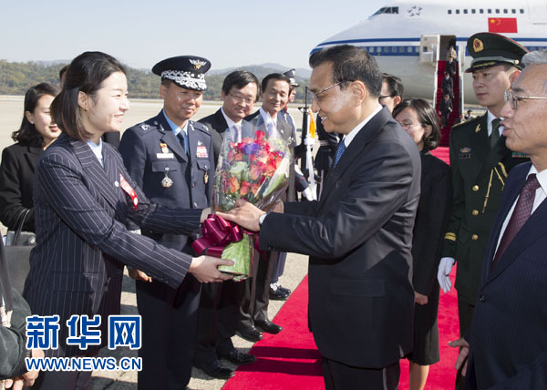 10月31日，應韓國總統樸槿惠邀請，中國國務院總理李克強乘專機抵達韓國首爾城南機場，開始對韓國進行正式訪問。這是韓國女青年在機場向李克強獻花。新華社記者 黃敬文 攝
