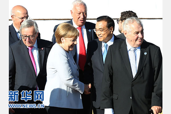 7月16日，國務院總理李克強在烏蘭巴托出席第十一屆亞歐首腦會議非正式會議，就國際和地區問題同與會領導人交換意見。這是會議開始前，與會領導人合影時，李克強與德國總理默克爾交談。新華社記者馬佔成攝