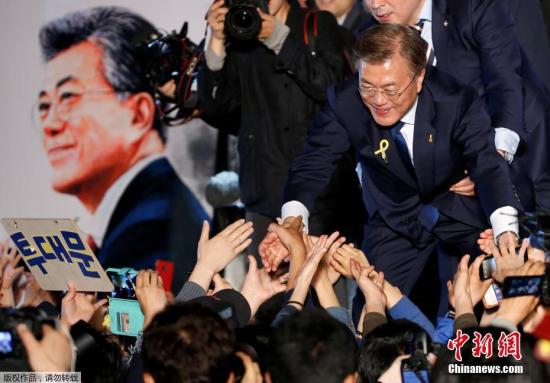 文在寅當選新一任韓國總統時，與民眾握手。