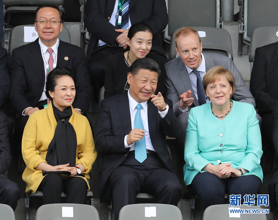 7月5日，國家主席習近平在柏林同德國總理默克爾共同觀看中德青少年足球友誼賽。這是習近平和夫人彭麗媛同默克爾在看臺上。 新華社記者 王曄攝