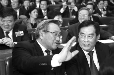 去年3月11日,第十一届全国人民代表大会第五次会议举行第四次全体会议。图为时任交通运输部部长李盛霖(左)与铁道部部长盛光祖(右)交谈。盛佳鹏 摄