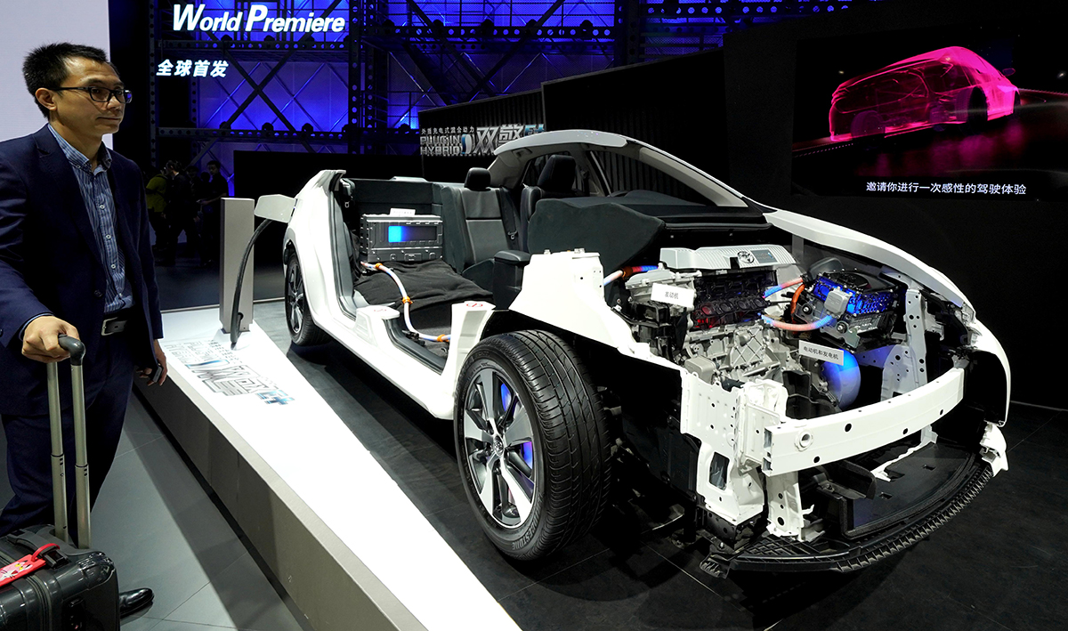 一位观众观看丰田汽车公司展出的外插充电式混合动力工作原理模型