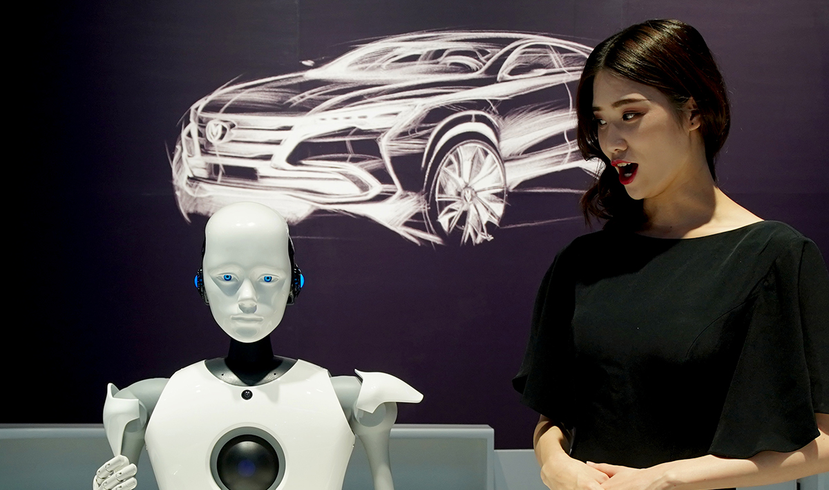 长安汽车展台上一个机器人和接待咨询人员交流