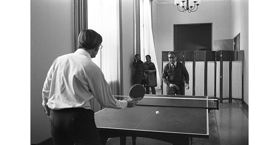 1971年10月26日，执掌美国国家安全委员会的总统国家安全顾问基辛格博士（Kissinger）（正对镜头带黑边眼镜）秘密访华，与其助手（后任驻华大使）温斯顿勋爵（Winston Lord）（背对镜头）在驻地打乒乓球。次年2月21日，美国总统尼克松首次访华，随后于上海发表《联合公报》。这场由中国邀请美国乒乓球队访华开始的&ldquo;乒乓外交&rdquo;，打开了隔绝22年的中美交往大门。