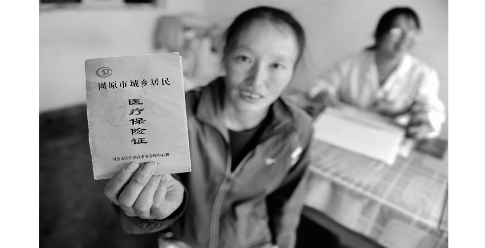 一位刚看完病的村民展示她的医疗保险证。宁夏回族自治区于2010年8月开始在石嘴山市和固原市试点统筹城乡基本医疗保险。新的医疗保险制度不再区分城市和农村户口，凡具有宁夏户籍的城乡居民都可参保。新华社记者 彭昭之 摄