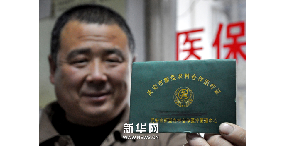 2013年3月25日，一名农民在河北省邯郸市第二医院展示他的新型农村合作医疗证。新华社发