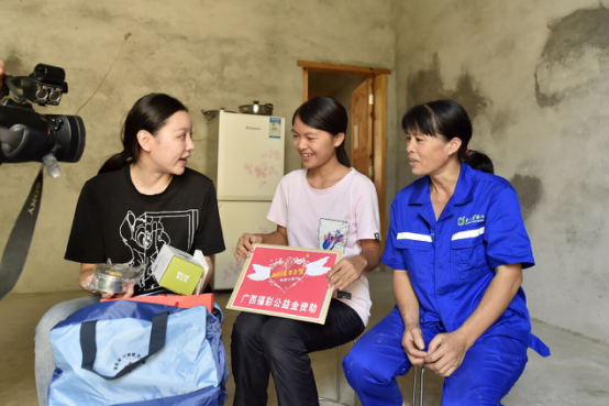 广西福彩中心工作人员来到广西柳州市柳江县的覃凡桃家中，给她送去助学金和慰问品。