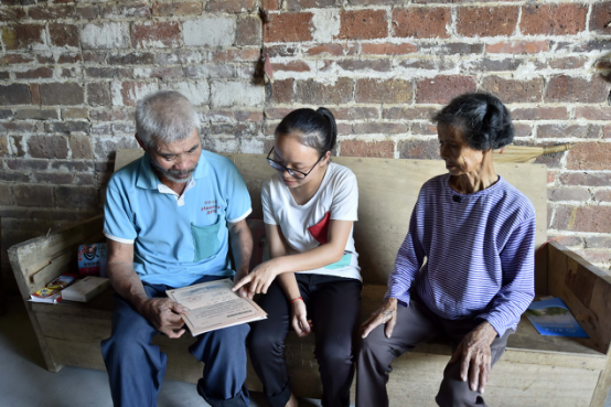 广西柳州市柳城县杨小露和爸爸、妈妈在家中聊天。