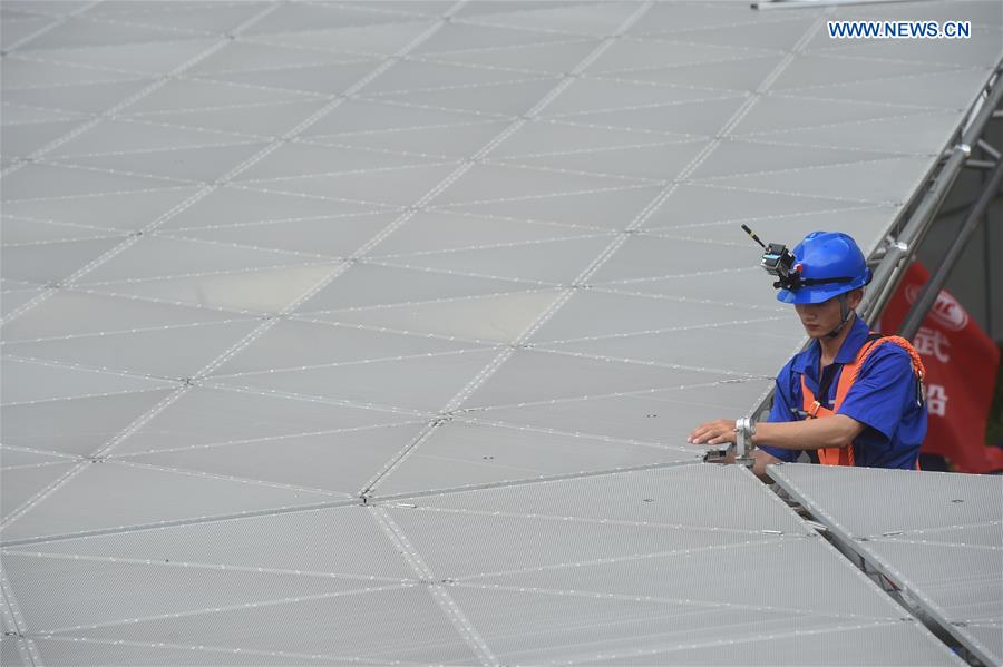 A worker installs the last triangular panel to the reflector of the Five-hundred-meter Aperture Spherical Telescope (FAST) in Pingtang County, southwest China's Guizhou Province, July 3, 2016. 