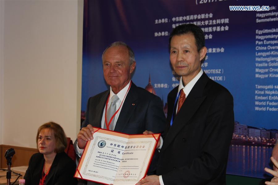 President of the Central and Eastern European Federation of Chinese Medicine Societies Yu Funian (R) presents the letter of appointment as Permanent Honorary President of the federation to former Hungarian Prime Minister Peter Medgyessy at the founding ceremony in Budapest, Hungary, March 4, 2017. 