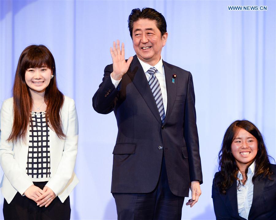 Japanese Prime Minister Shinzo Abe (C) pose with Japanese athletes during the 84th congress of Japan's ruling Liberal Democratic Party in Tokyo, Japan, March 5, 2017. 