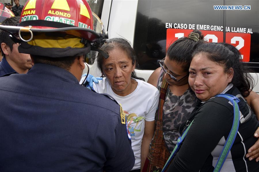 A woman is treated by paramedics near the scene of a fire in San Jose Pinula, near Guatemala City, Guatemala, on March 8, 2017. 